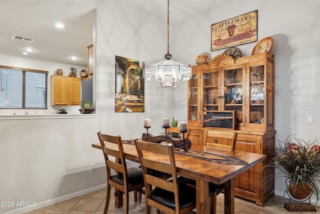 dining area with a notable chandelier and light tile patterned flooring