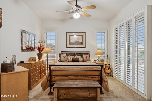 carpeted bedroom featuring ceiling fan, access to outside, and multiple windows