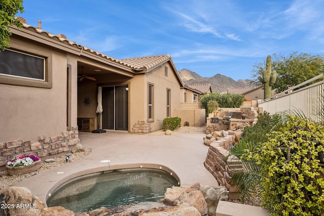 view of patio / terrace featuring area for grilling, a mountain view, and a hot tub