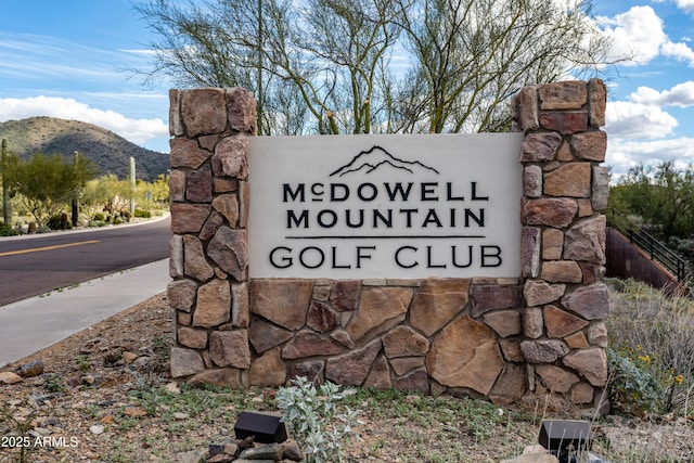 community / neighborhood sign with a mountain view