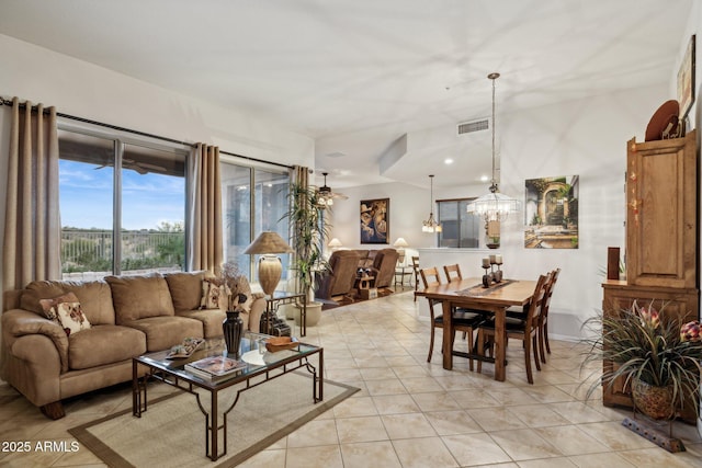 tiled living room with a notable chandelier