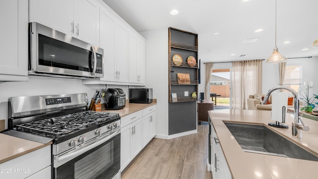 3117 E Hayfield Way, San Tan Valley, AZ 85140 - kitchen with stainless steel appliances, a sink, light wood-type flooring, plenty of natural light, and recessed lighting