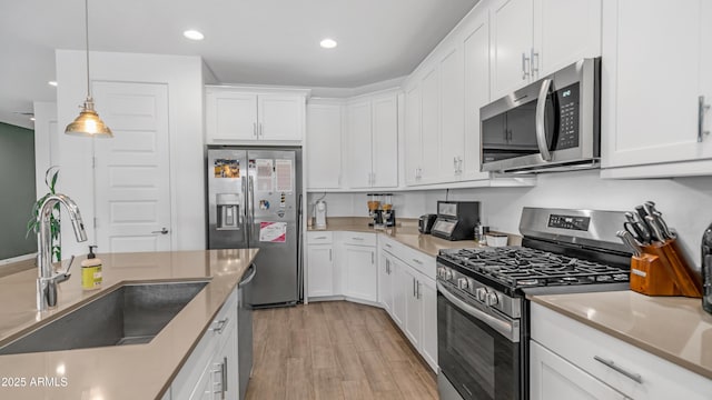 3117 E Hayfield Way, San Tan Valley, AZ 85140 - kitchen with stainless steel appliances, a sink, light wood-type flooring, white cabinets, and recessed lighting