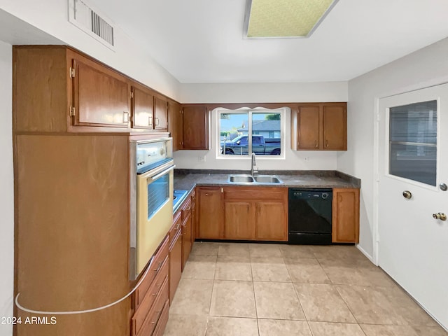 kitchen with oven, light tile patterned floors, dishwasher, and sink