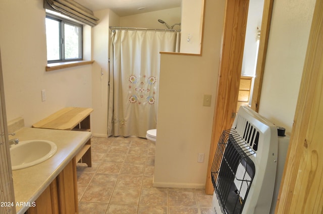 bathroom featuring vanity, heating unit, vaulted ceiling, tile patterned flooring, and toilet