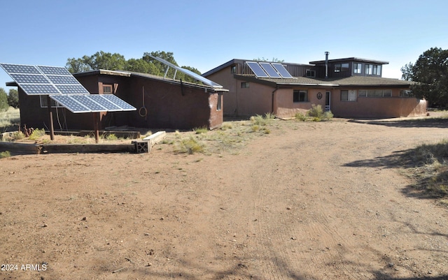 back of property featuring solar panels