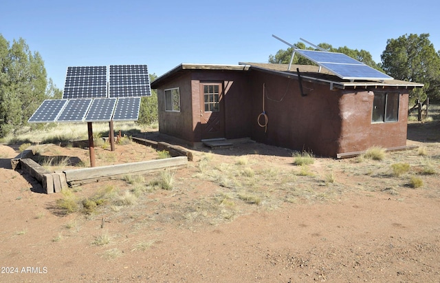 rear view of house featuring solar panels