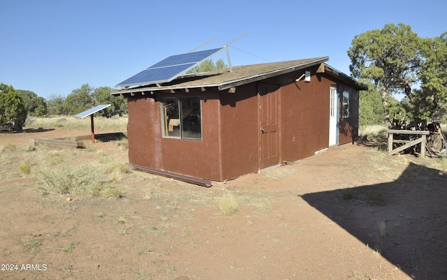 view of side of home featuring solar panels