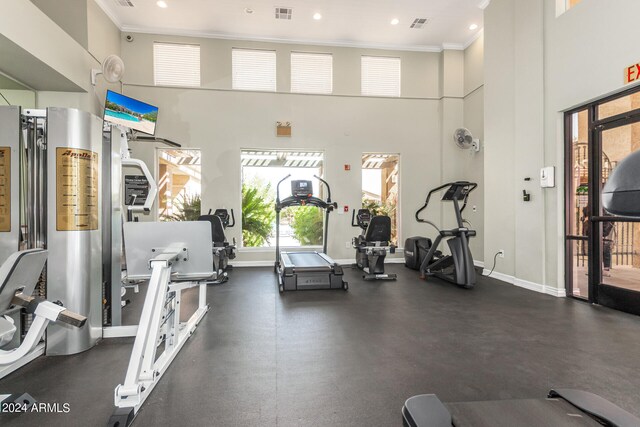 exercise room with a high ceiling and ornamental molding