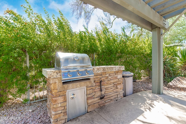 view of patio featuring an outdoor kitchen and a grill