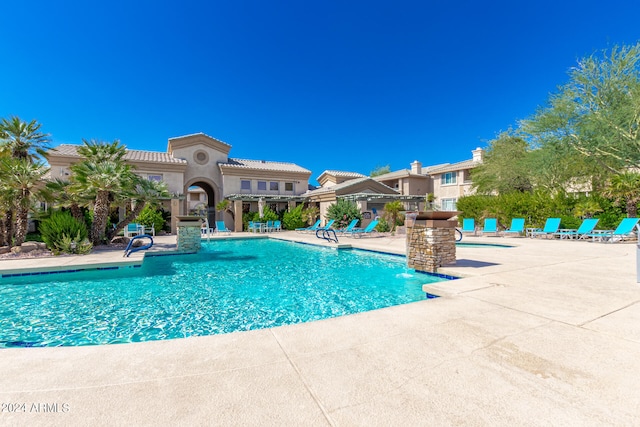 view of pool featuring pool water feature and a patio