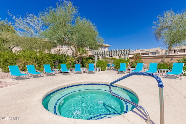 view of swimming pool with a hot tub and a patio