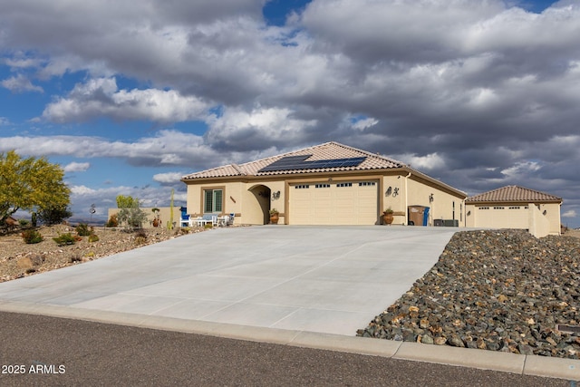 965 Calle Azul, Wickenburg, AZ 85390 - mediterranean / spanish-style home featuring stucco siding, a garage, roof mounted solar panels, a tiled roof, and concrete driveway