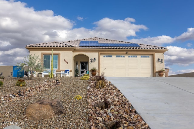 965 Calle Azul, Wickenburg, AZ 85390 - mediterranean / spanish home with roof mounted solar panels, driveway, a tiled roof, stucco siding, and a garage