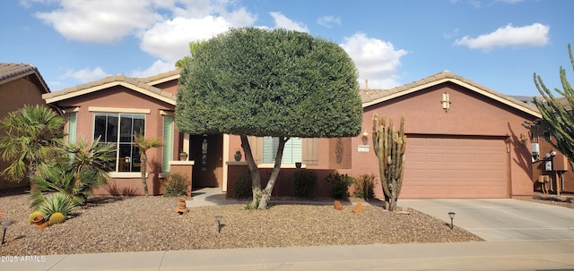 single story home featuring concrete driveway, an attached garage, a tile roof, and stucco siding