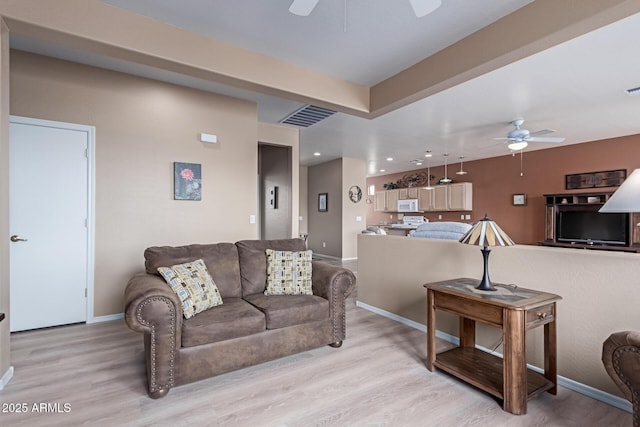 living room with visible vents, ceiling fan, and light wood-style flooring