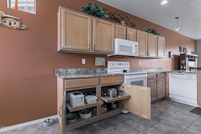 kitchen featuring a textured wall, light brown cabinets, white appliances, baseboards, and light countertops