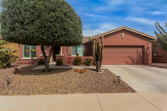 view of front of home with a garage, concrete driveway, a tile roof, and stucco siding