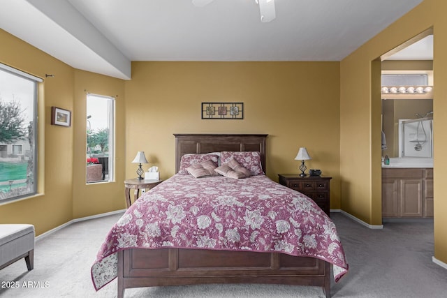 carpeted bedroom with connected bathroom, a ceiling fan, and baseboards