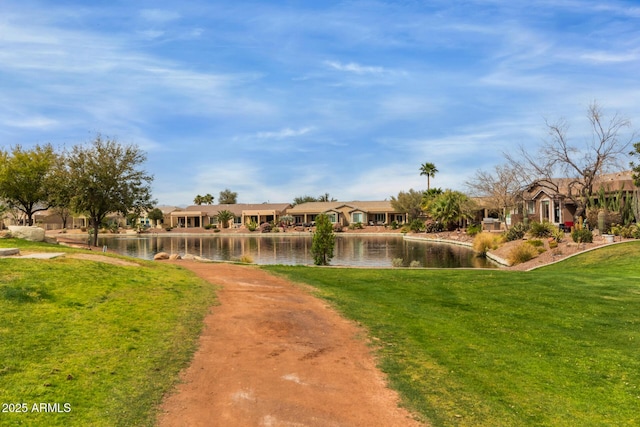 view of property's community with a lawn, a water view, and a residential view