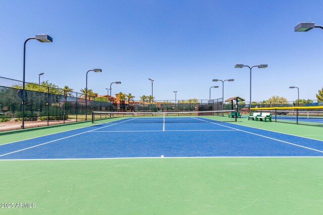 view of tennis court featuring fence