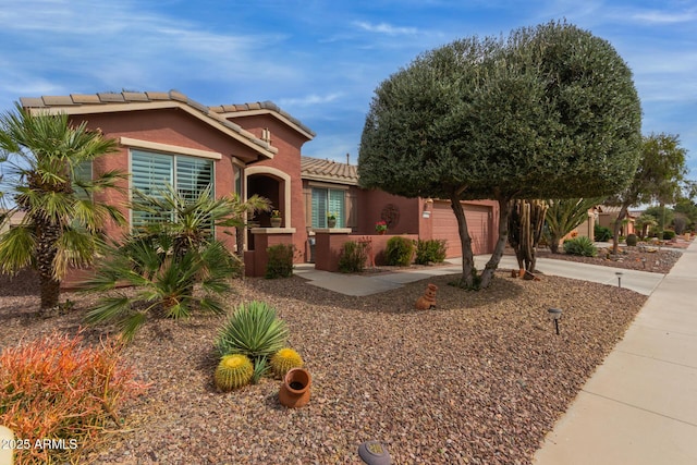 view of front facade with a fenced front yard, a garage, a tile roof, concrete driveway, and stucco siding