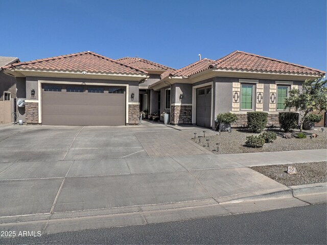 21696 E Arroyo Verde Dr, Queen Creek, AZ 85142 - view of front facade featuring a tiled roof, stone siding, a garage, concrete driveway, and stucco siding