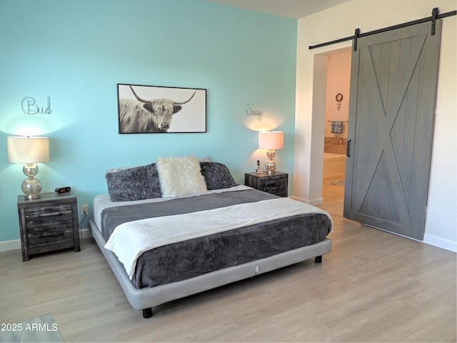 21696 E Arroyo Verde Dr, Queen Creek, AZ 85142 - bedroom with light wood-type flooring, ensuite bathroom, baseboards, and a barn door