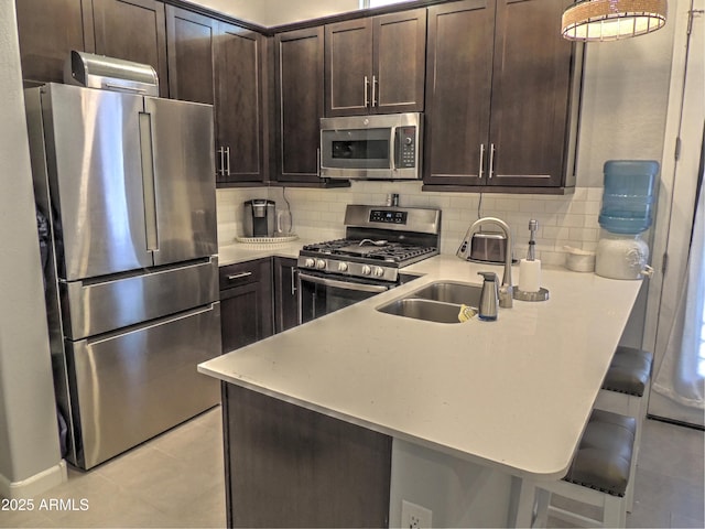 21696 E Arroyo Verde Dr, Queen Creek, AZ 85142 - kitchen with appliances with stainless steel finishes, a sink, backsplash, and dark brown cabinetry