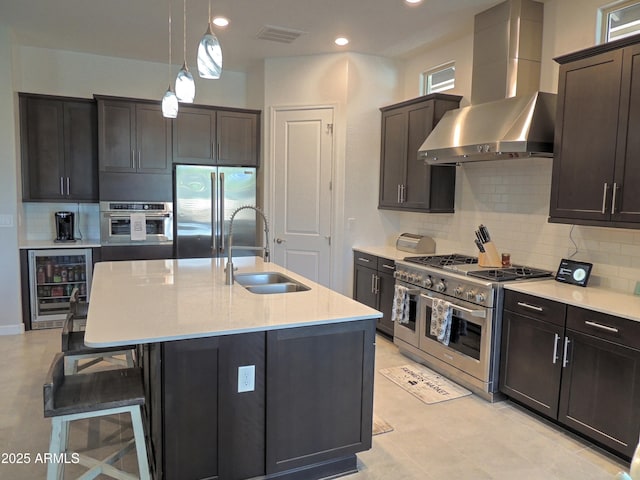 21696 E Arroyo Verde Dr, Queen Creek, AZ 85142 - kitchen with appliances with stainless steel finishes, visible vents, wall chimney exhaust hood, wine cooler, and a sink
