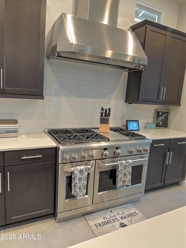 21696 E Arroyo Verde Dr, Queen Creek, AZ 85142 - kitchen with range hood, dark brown cabinetry, tasteful backsplash, double oven range, and light countertops