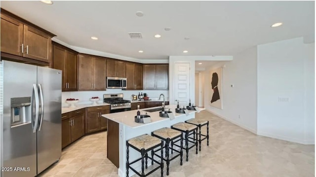 23081 E Saddle Way, Queen Creek, AZ 85142 - kitchen with stainless steel appliances, recessed lighting, a kitchen breakfast bar, a sink, and a kitchen island with sink