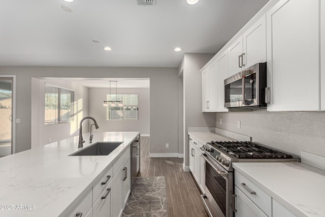 kitchen featuring light stone countertops, sink, white cabinetry, and stainless steel appliances