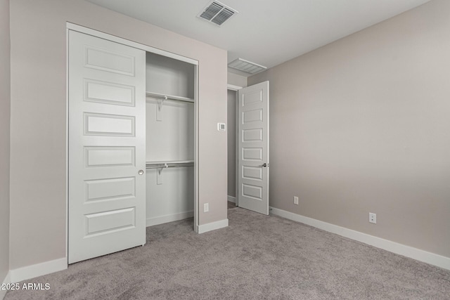 unfurnished bedroom featuring light colored carpet and a closet