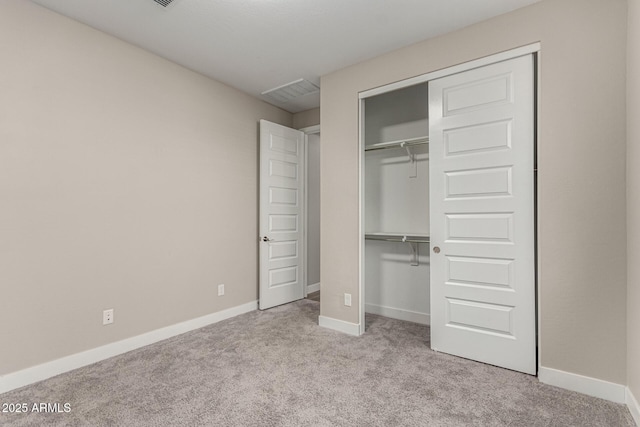 unfurnished bedroom with light carpet and a closet