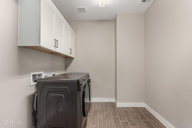 laundry room featuring washer and clothes dryer and cabinets