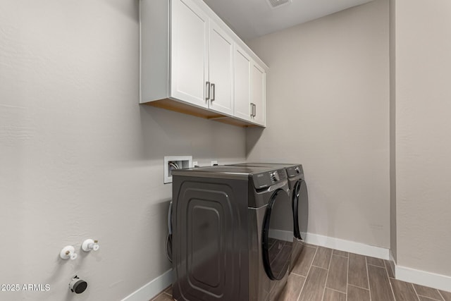 washroom with washer and clothes dryer and cabinets