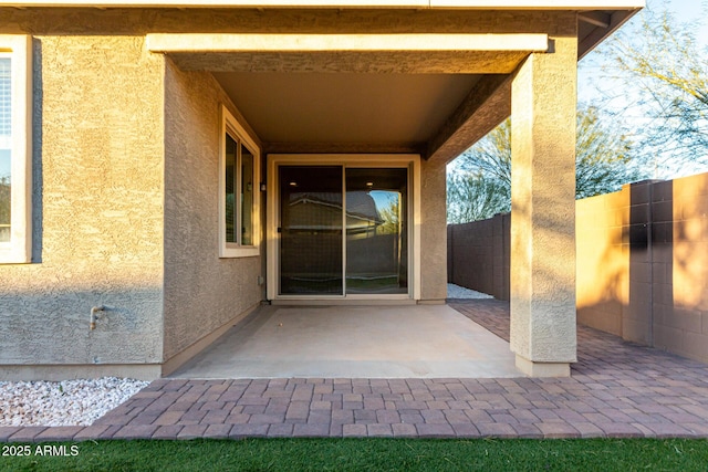 view of exterior entry featuring a patio