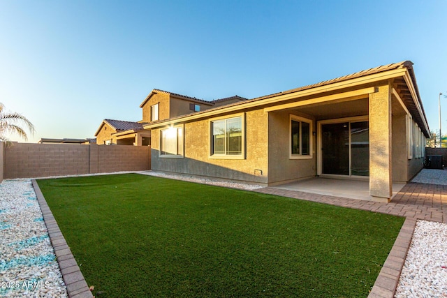 back of house featuring a patio area and a yard