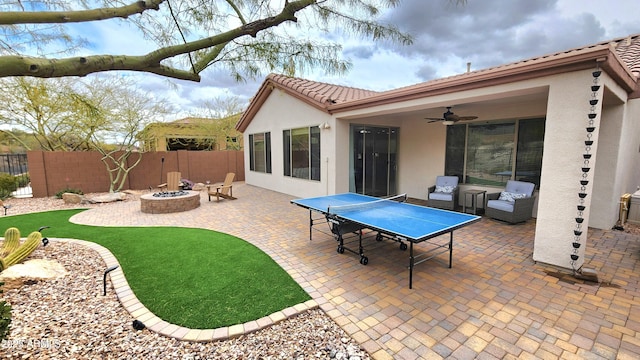 view of patio with ceiling fan, fence, and an outdoor fire pit