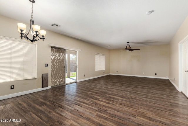 empty room featuring ceiling fan with notable chandelier and dark wood-type flooring