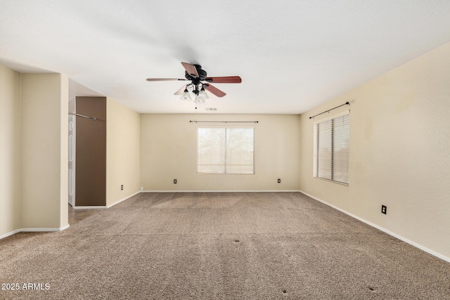 carpeted spare room featuring ceiling fan