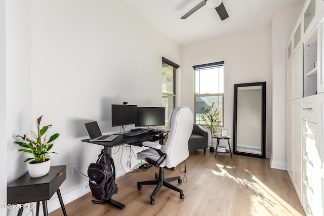 office with light wood-type flooring and ceiling fan