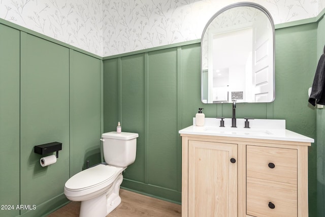 bathroom featuring wood-type flooring, vanity, and toilet