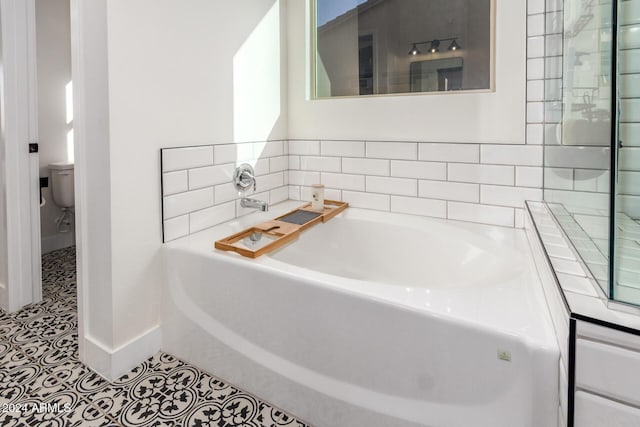 bathroom with a bathing tub, toilet, and tile patterned floors