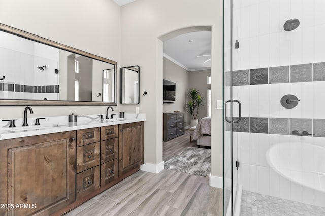 8848 E Conquistadores Dr, Scottsdale, AZ 85255 - bathroom featuring a stall shower, double vanity, crown molding, a garden tub, and wood finished floors