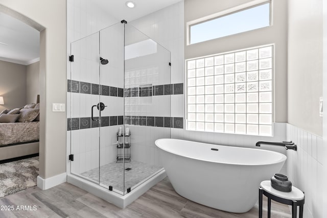 8848 E Conquistadores Dr, Scottsdale, AZ 85255 - full bath with ensuite bath, a freestanding bath, a shower stall, tile walls, and wood finished floors