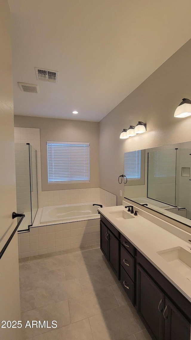 bathroom with tile patterned floors, vanity, and separate shower and tub