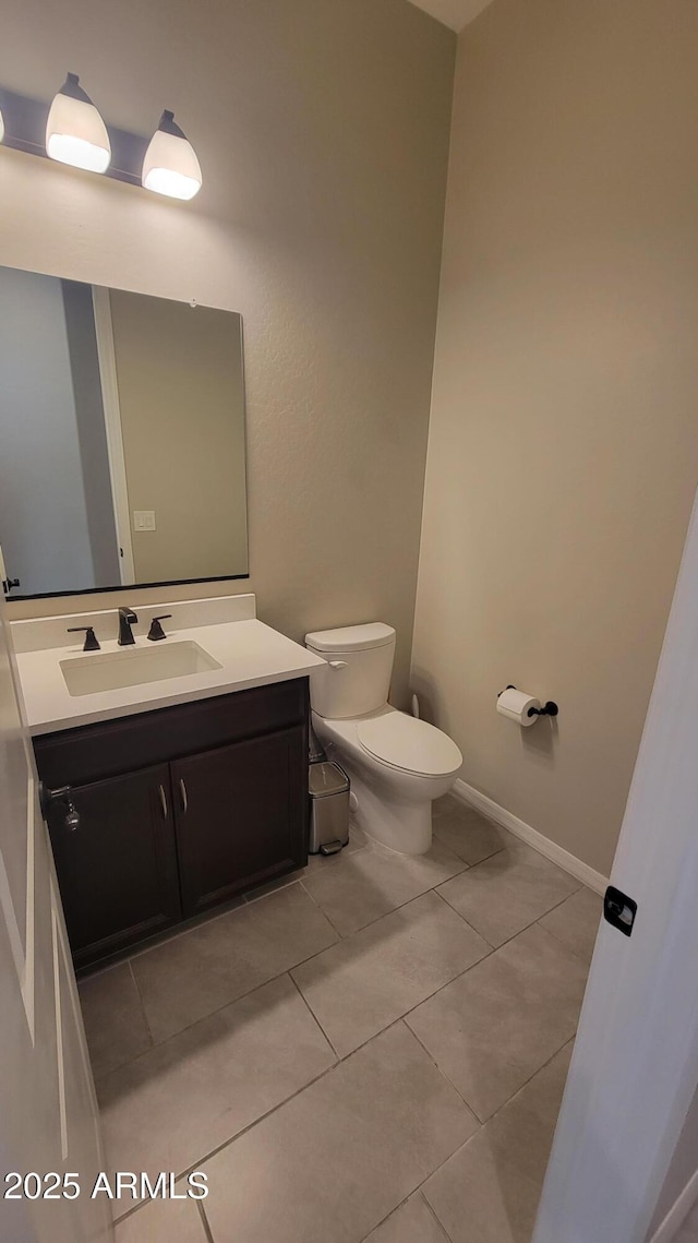 bathroom featuring tile patterned flooring, vanity, and toilet