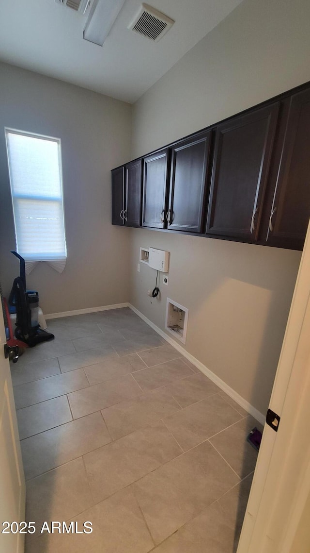 washroom featuring cabinets, washer hookup, electric dryer hookup, hookup for a gas dryer, and light tile patterned floors